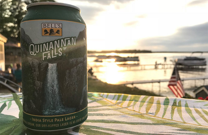 A can of Quinannan Falls lakeside with the sun setting in the background.
