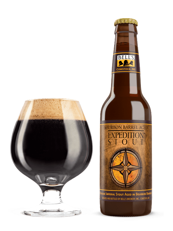 A full snifter glass sitting next to a bottle of Bourbon Barrel Aged Expedition Stout