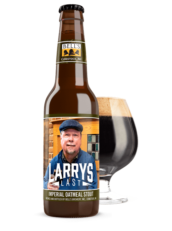 A bottle of Larry's Last sitting in front of a full snifter glass