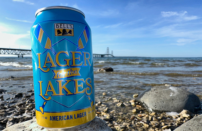 A can of Lager for the Lakes on the beach with the Mackinac Bridge behind it.